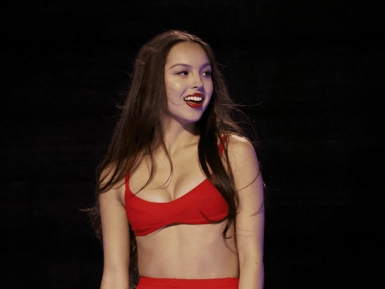 Olivia Rodrigo em um sutiã vermelho e com batom vermelho no VMAS 2024