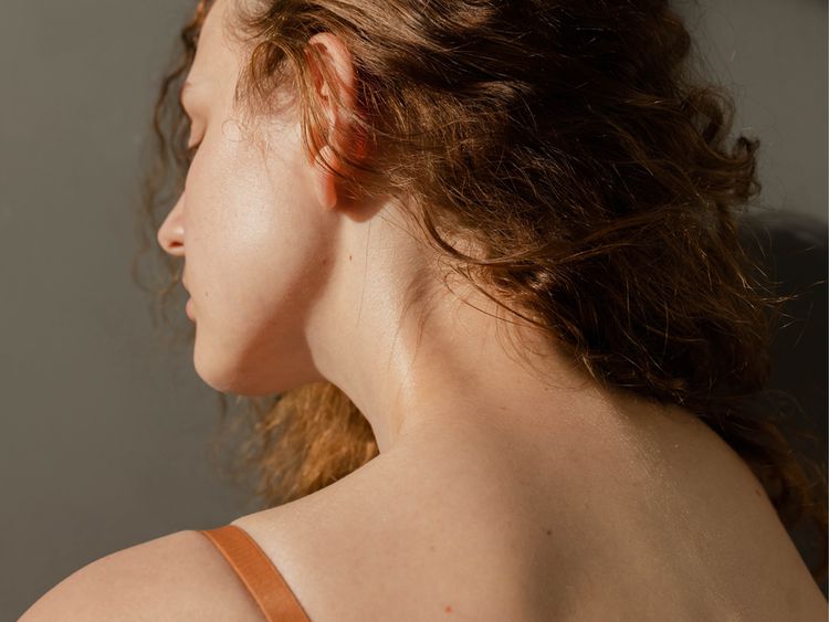 Uma mulher demonstra o pescoço e as costas